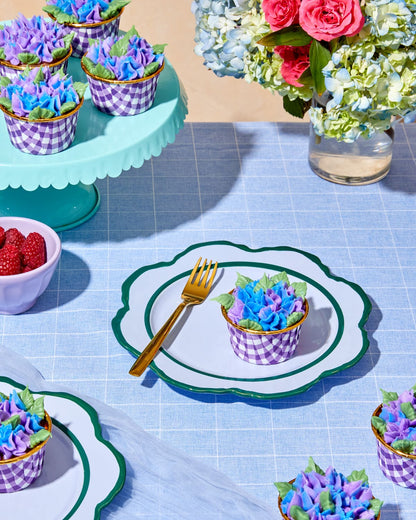 Raspberry rose cupcakes with purple and blue hydrangea buttercream on a styled table setting with pink and blue florals, gold utensils, created using Foxiecakes Hamptons Beach House baking kit