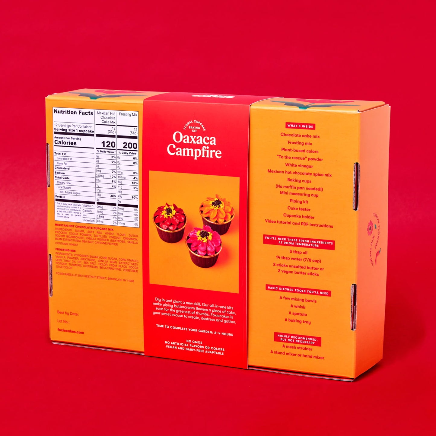 Back of Foxiecakes Oaxaca Campfire floral cupcake baking kit box on a red background, showing nutrition facts, ingredient information, and a list of recommended basic tools you'll need for a beginner-friendly DIY spiced hot chocolate cupcake decorating kit