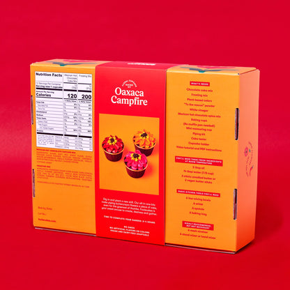 Back of Foxiecakes Oaxaca Campfire floral cupcake baking kit box on a red background, showing nutrition facts, ingredient information, and a list of recommended basic tools you'll need for a beginner-friendly DIY spiced hot chocolate cupcake decorating kit