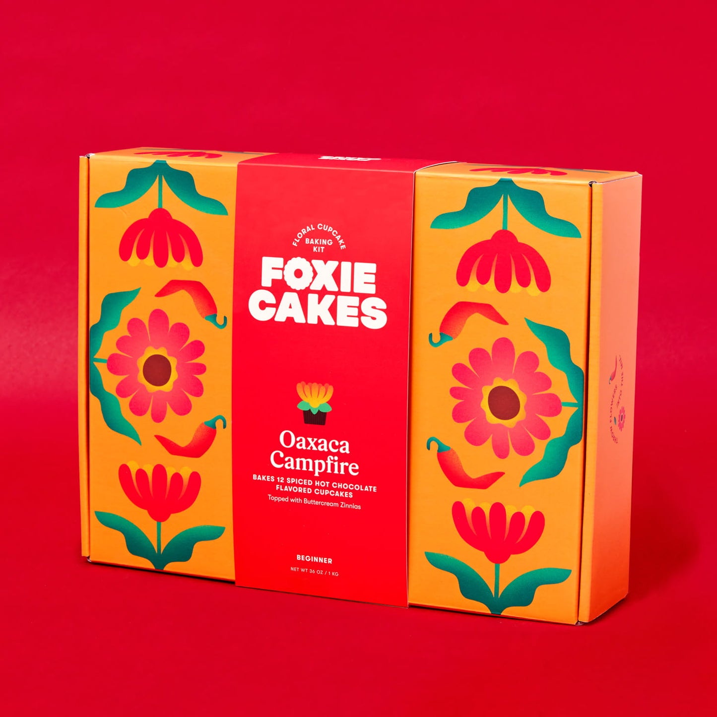 Foxiecakes Oaxaca Campfire beginner DIY floral cupcake baking kit box featuring red and orange floral packaging, designed to make 12 spiced hot chocolate flavored cupcakes with zinnia-style buttercream frosting, ideal for at-home baking, gifting, and creative dessert decorating experiences