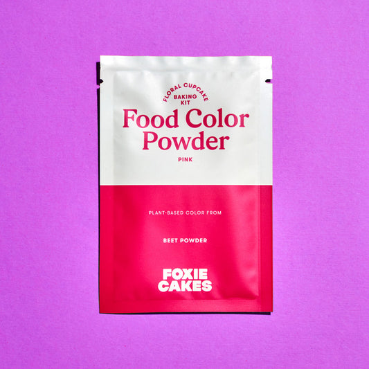 Foxiecakes pink food color powder packet on a purple background